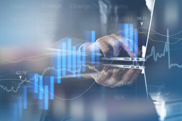 Businessman monitoring stock market report on laptop computer with financial graph on virtual...