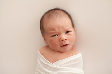 Portrait of a newborn baby boy with emotion on his face