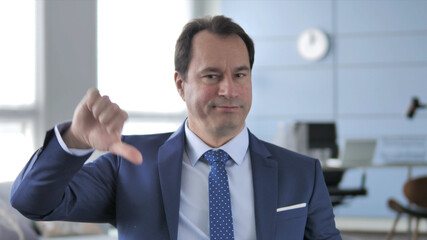 Thumbs Down by Middle Aged Businessman