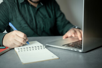 Man sliding on keyboard of laptop for check order and note to preparation sent order.