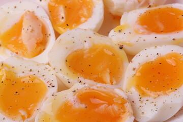 soft-boiled sunny side up halves of chicken eggs on the white plate bright orange background. close up shot. minimalism concept
