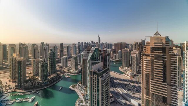 Dubai Marina skyscrapers and jumeirah lake towers panoramic view during sunrise from the top aerial morning timelapse in the United Arab Emirates. Traffic on roads