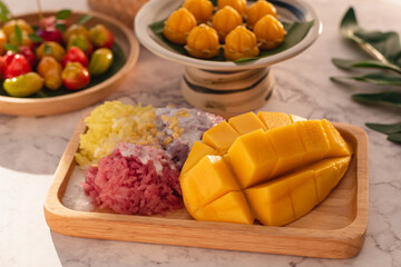 Thai style tropical dessert, Yellow mango eat with Three color of Glutinous rice from natural organic, Selective focus, Blur of Thai dessert background with day light.
