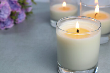 Fototapeta na wymiar The luxury lighting aromatic scented candle glass diplay on the grey table in the white bedroom with background of the marble wall in the morning to create romantic and relax ambient on valentine day
