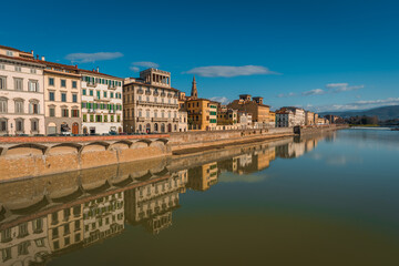 FLORENCE, TUSCANY / ITALY - DECEMBER 27 2019: Buildings reflecion in Arno river water in Florence