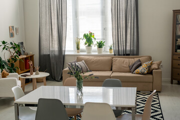 Interior of comfortable domestic room in flat or house with table in the center