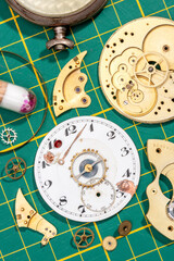 old chronograph dismantled on green background