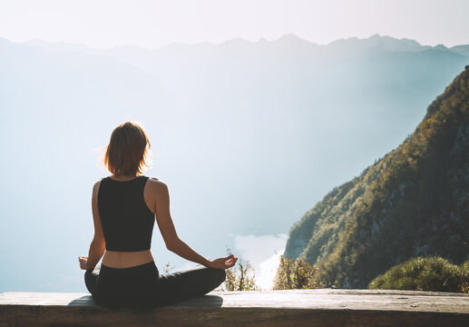 Young woman is meditating in mountains.