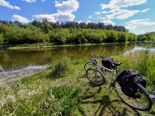 Fototapeta na wymiar Dwa rowery nad rzeką w słoneczny dzień