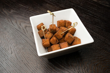 square croutons in white plate
