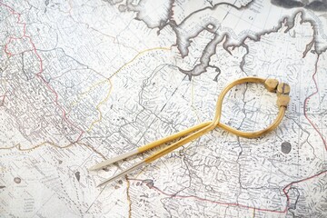 Antique W & HC 6" brass dividers calipers nautical navigation chart tool, old white chart close-up. Vintage still life. Sailing, travel accessories. Planning, adventure, hobby, recreation, concept art