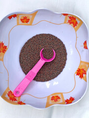 Mustard seeds in a bowl with spoon