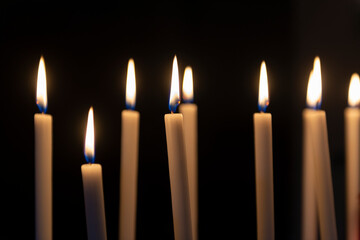 Burning candles on dark background.