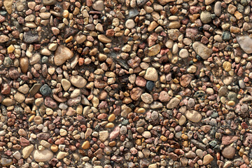 Texture of an old wall decorated with small pebbles.