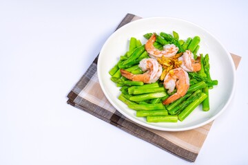 Stirred fried asparagus with shrimp served on white plate isolated on white background. famous thai food in thailand. popular food in Asia.