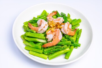 Stirred fried asparagus with shrimp served on white plate isolated on white background. famous thai food in thailand. popular food in Asia.