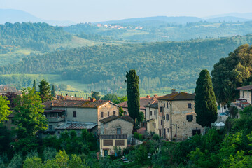 Fototapeta na wymiar Residential buildings with a Tuscan countryside in the background in San Gimignano, Province of Siena, Italy.