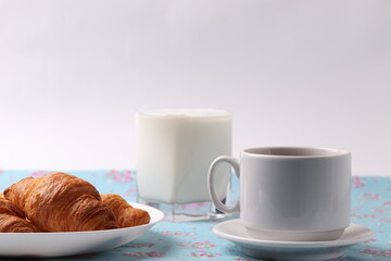 delicious french croissants and a white ceramic coffee cup 