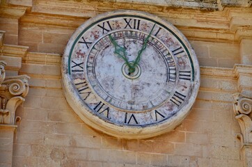 Fototapeta na wymiar Historical clock on the Roman Catholic Cathedral of Saint Paul in main town square of Mdina village in Malta