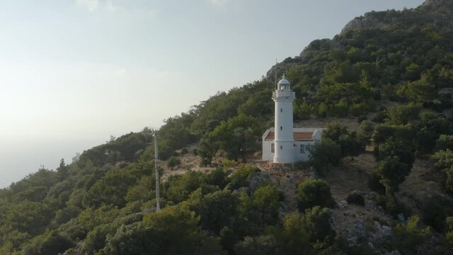 Gelidonya lighthouse on a background of mountains. Beautiful ladscape with dense forest. Drone footage 4K