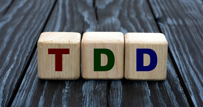 concept word TDD on cubes on a beautiful gray blue background