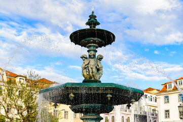 Fototapeta na wymiar It's Fountain of the Rossio Square (Pedro IV Square) in Lisbon, Portugal. The square became an important place in the city since the 13th and 14th centuries