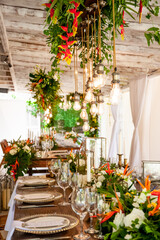 Table setting served and decorated for party event with plates, glasses, candles, napkins, lamps, flowers and invitations. Guests table, Wedding reception, Birthday, anniversary. Holiday evening