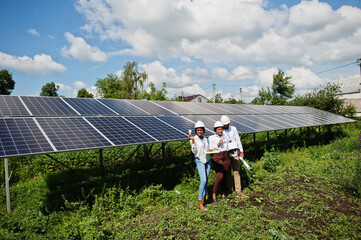 African american technician checks the maintenance of the solar panels. Group of three black...