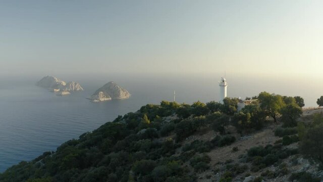 An old lighthouse facing the Greek islands. Mountain landscape from above. Mediterranian sea. Drone footage 4K.