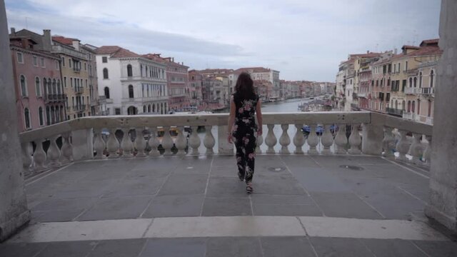 Actractive young woman walk on the bridge of Rialto in Venice Italy looking at the Grand Canal