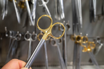 a pair of surgical scissors is taken out of the cabinet in a sterilization department - Powered by Adobe