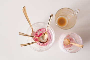 Group of empty unwashed glasses and teaspoons on kitchen table after breakfast
