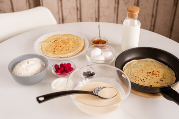 Served table with hot pancakes, dairy products, eggs, fresh berries and honey