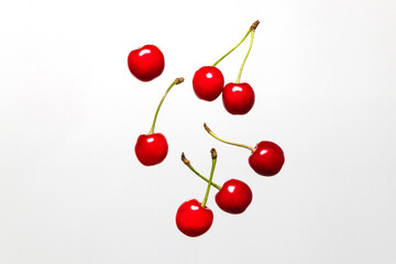 Obraz na płótnie Canvas Ripe cherry berry levitating on a grey background. Cherry pattern. Berry summer background. Flat lay, top view, copy space