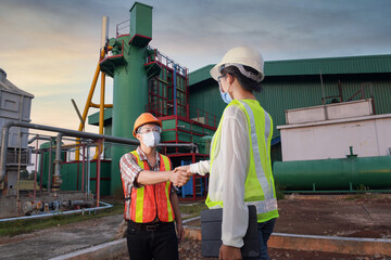 Construction engineers supervising progress of construction project stand on new factory,Engineering Consulting People on construction site holding blueprint in his hand. Building inspector. 