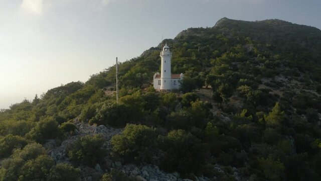 Gelidonya lighthouse on a background of mountains. Beautiful ladscape with dense forest. Drone footage 4K
