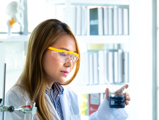 Young female doing experiments and researchers working in the laboratory.