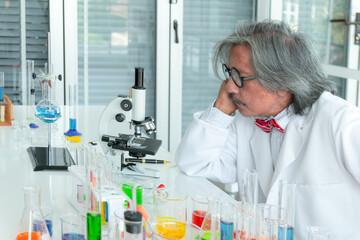 Serious senior male supervisor researchers and experiment working in life science laboratory.