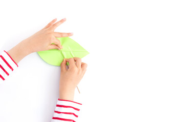 kids hands push strips on a green leaf shape paper detail, simple paper craft for kid and kindergarten, step by step instruction, tutorial, DIY, snail project, step4, © Elena