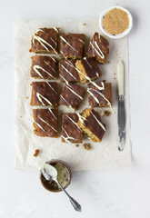 cake with chocolate. Closeup of blondies, pastry made from white chocolate (similar to brownies), cut into square pieces, on light background