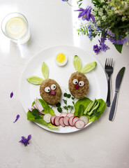 Creative idea for a kids breakfast, rabbits cutlet and vegetables. Food art idea. Children, holidays, Easter, healthy, proper nutrition concept. Free space for text. Baby food. Food art for children