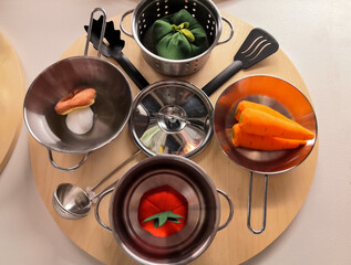 Decorative vegetables lie in a metal dish. The composition of the table setting