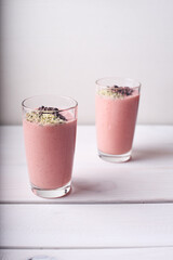Two strawberry raspberry smoothies with hemp seed topping