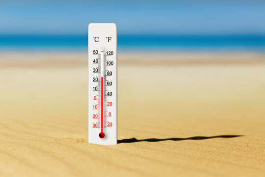 Summer heat. Thermometer in the sand shows plus 25 degrees celsius. Sea coast at hot summer day
