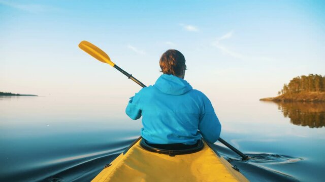 self-isolation in outdoor activities, a man kayaking on a calm lake at sunset