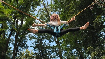 Teenage girl silhouette jumping on the trampoline bungee jumping.