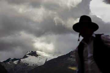 Andes mountain with silhouette of unrecognizable man with clouds.