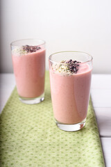 Two strawberry raspberry smoothies with cocoa bean topping