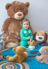 Cute child having fun playing with his teddy bears and plush toys, at home
