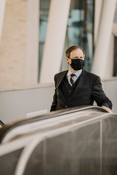 Europe, Germany, Hamburg, Hafencity, Businessman wearing a respirator face mask in public on a staircase